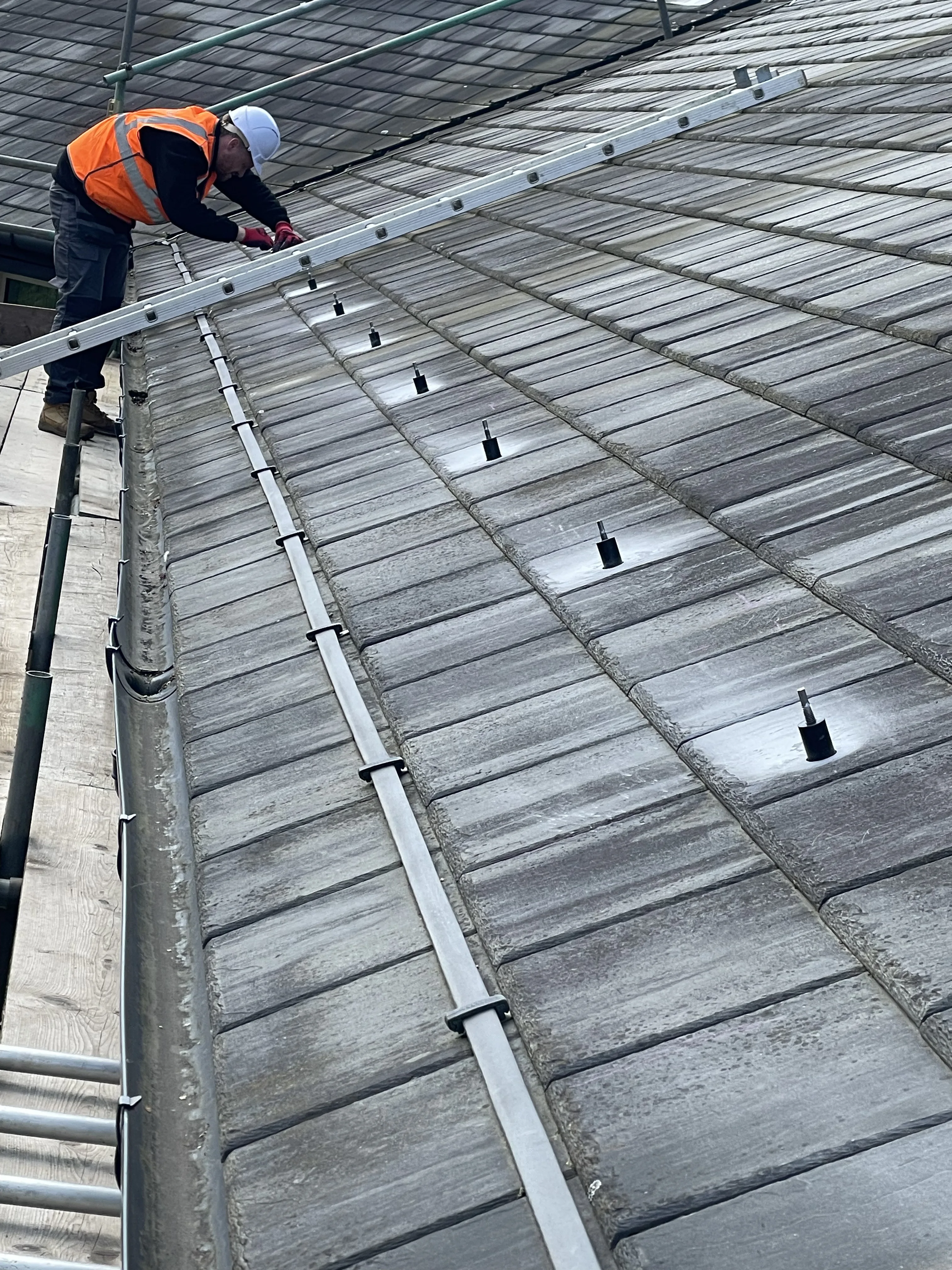 Eight SolVe Mounts installed in a row on a slate roof
